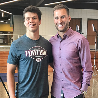 Kirk Cousins smiling at the camera with HCHS football player