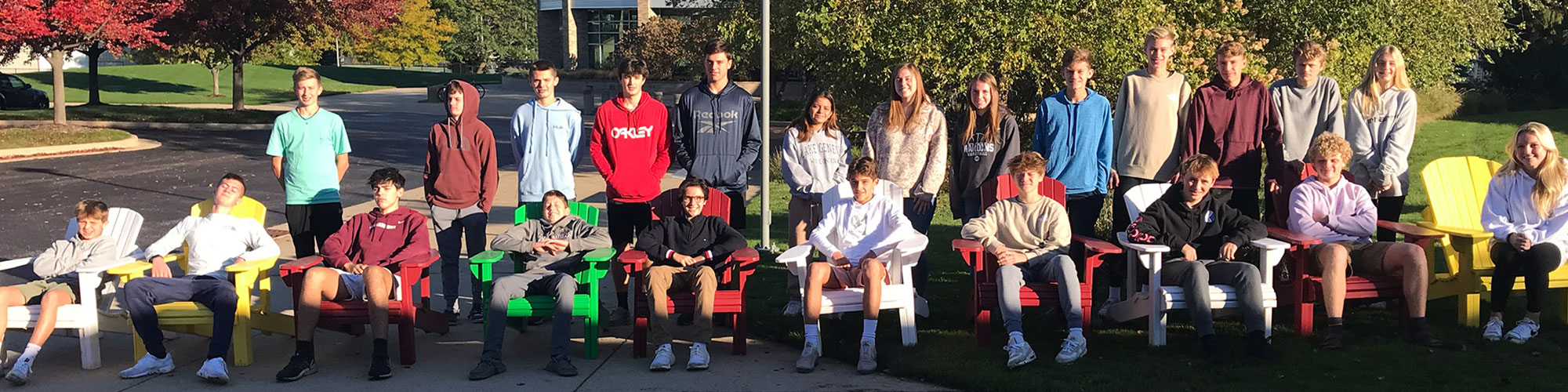 HCHS Woods students smiling from their Adirondack chairs they made