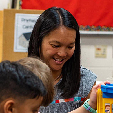 Preschool teacher Leanne Bouwman helping students play.