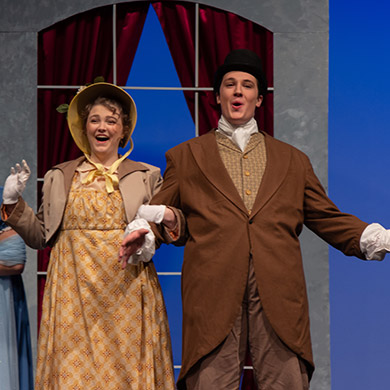 Actor and actress facing the audience smiling together