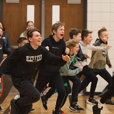 Students cheering and running out on the gym floor together