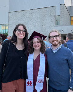 Anna Jackson and two older siblings at her graduation, standing and smiling for the camera.
