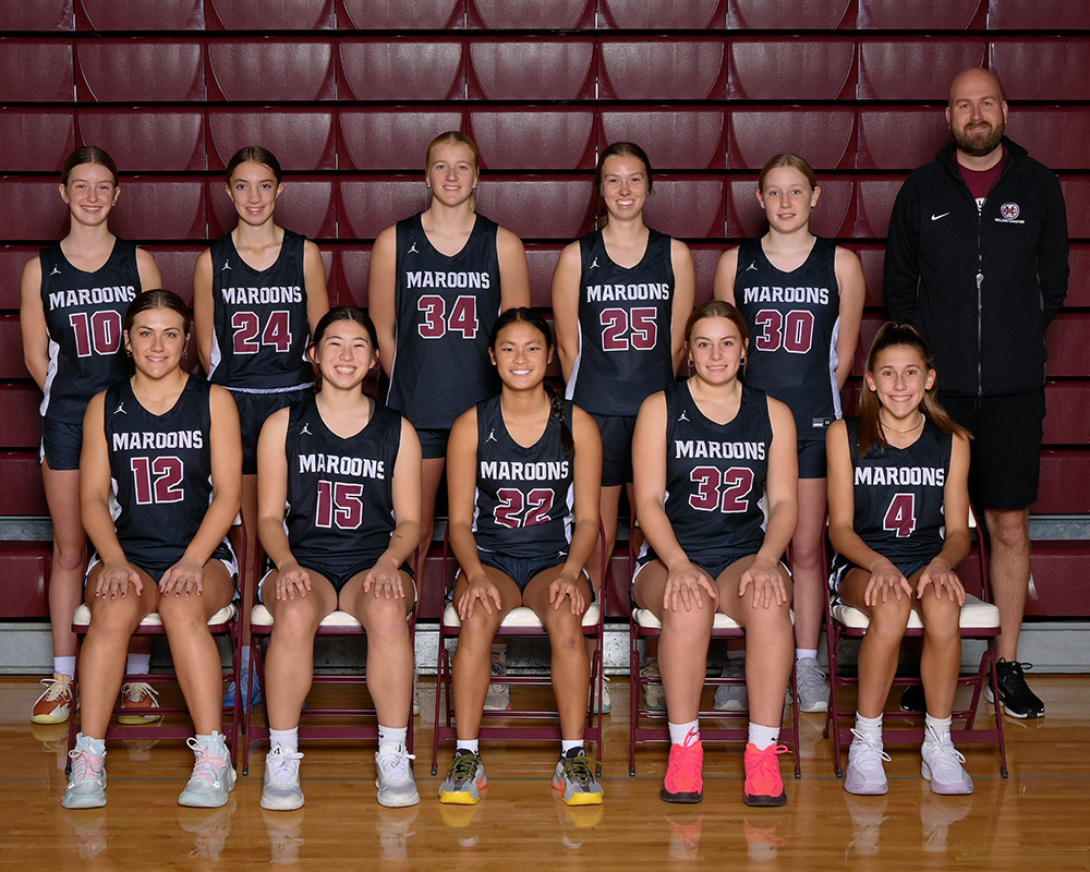 JV girls basketball team smiling at the camera