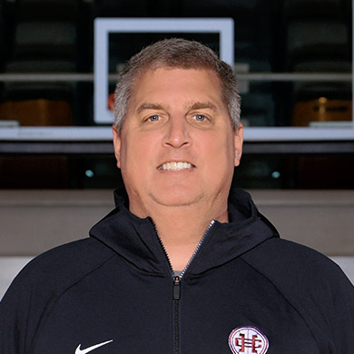 Varsity girls basketball team coach smiling at the camera