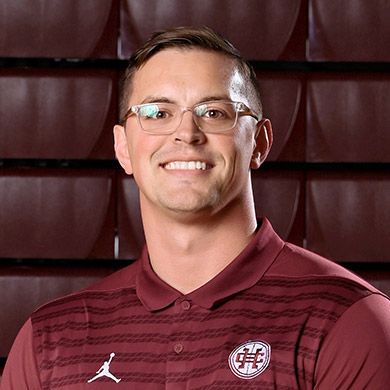 Boys JV basketball coach Snikkers smiling at the camera.