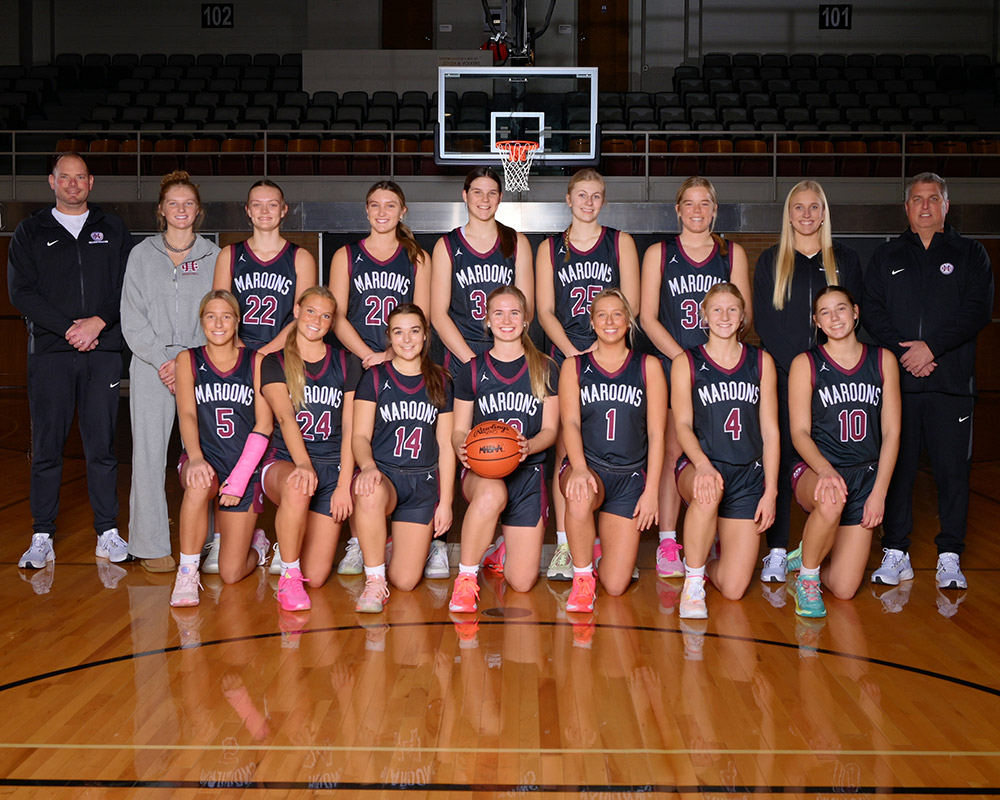 Varsity girls basketball team smiling at the camera.